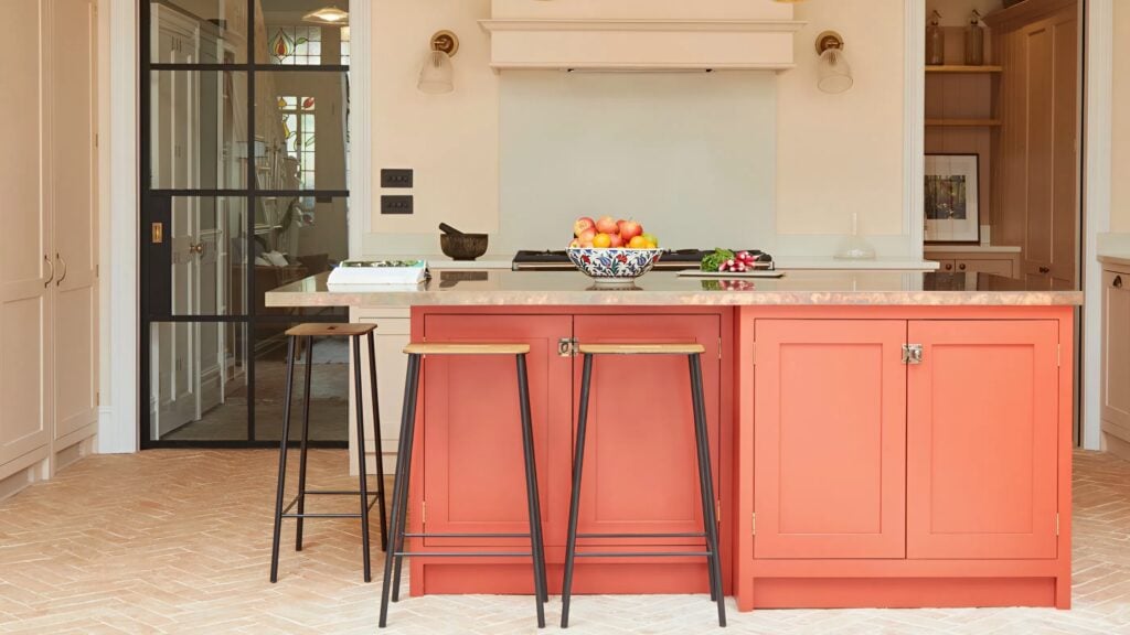 Coral painted kitchen island cabinets with a smooth satin finish, highlighting detailed cabinet refinishing work