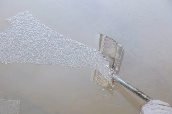 Professional interior painter in Goochland, VA scraping popcorn ceiling texture during a ceiling removal project.